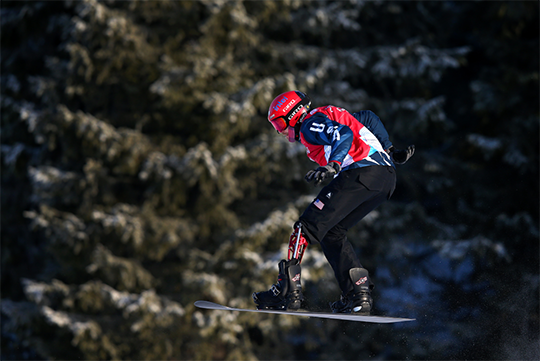A Paralympic snowboarder mid-air at the Beijing 2022 Winter Paralympic Games.