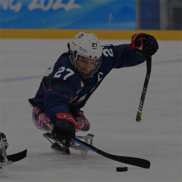 A men's Para Ice Hockey player mid-match at the Paralympic Games.